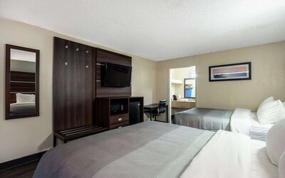 Guest room with two double beds, wall-mounted TV, mini fridge and workspace at Quality Inn Yemassee - Point South I-95.