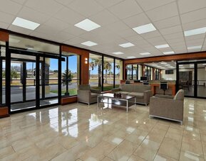 Lobby lounge with cushioned seating, business center workstations and floor-to-ceiling windows at Quality Inn Yemassee - Point South I-95.