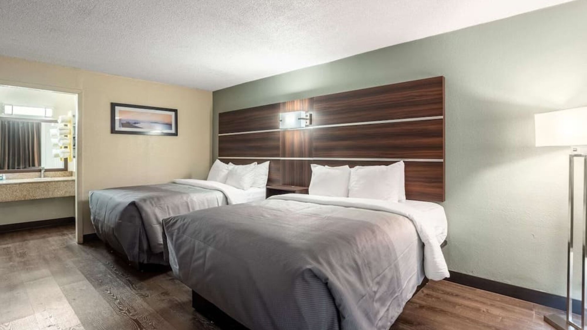 Guest room with two double beds, open vanity area and wood-look flooring at Quality Inn Yemassee - Point South I-95.