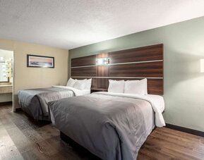 Guest room with two double beds, open vanity area and wood-look flooring at Quality Inn Yemassee - Point South I-95.