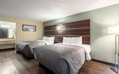 Guest room with two double beds, open vanity area and wood-look flooring at Quality Inn Yemassee - Point South I-95.