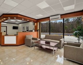 Lobby lounge with reception desk, sofas and large windows overlooking the parking area at Econo Lodge Yemassee.