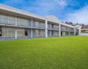 Two-story hotel exterior overlooking a spacious grassy courtyard with guest room balconies at Econo Lodge Yemassee.