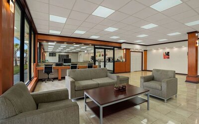 Open lobby seating area with business center workstations, sofas and tiled flooring at Econo Lodge Yemassee.