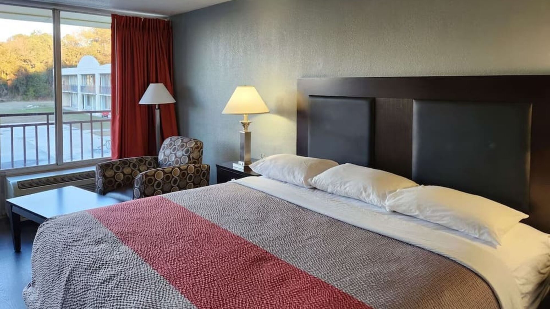 King guest room with large window, seating area and courtyard views at Econo Lodge Yemassee.