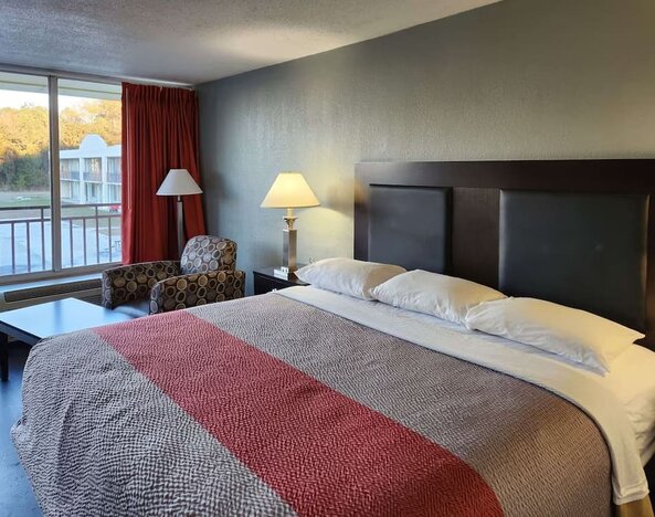King guest room with large window, seating area and courtyard views at Econo Lodge Yemassee.