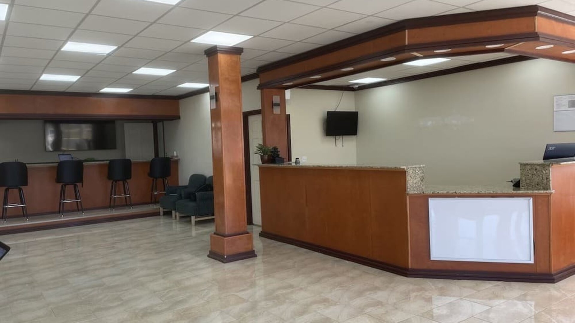 Reception desk with polished tile flooring, guest seating and check-in counter at Econo Lodge Yemassee.