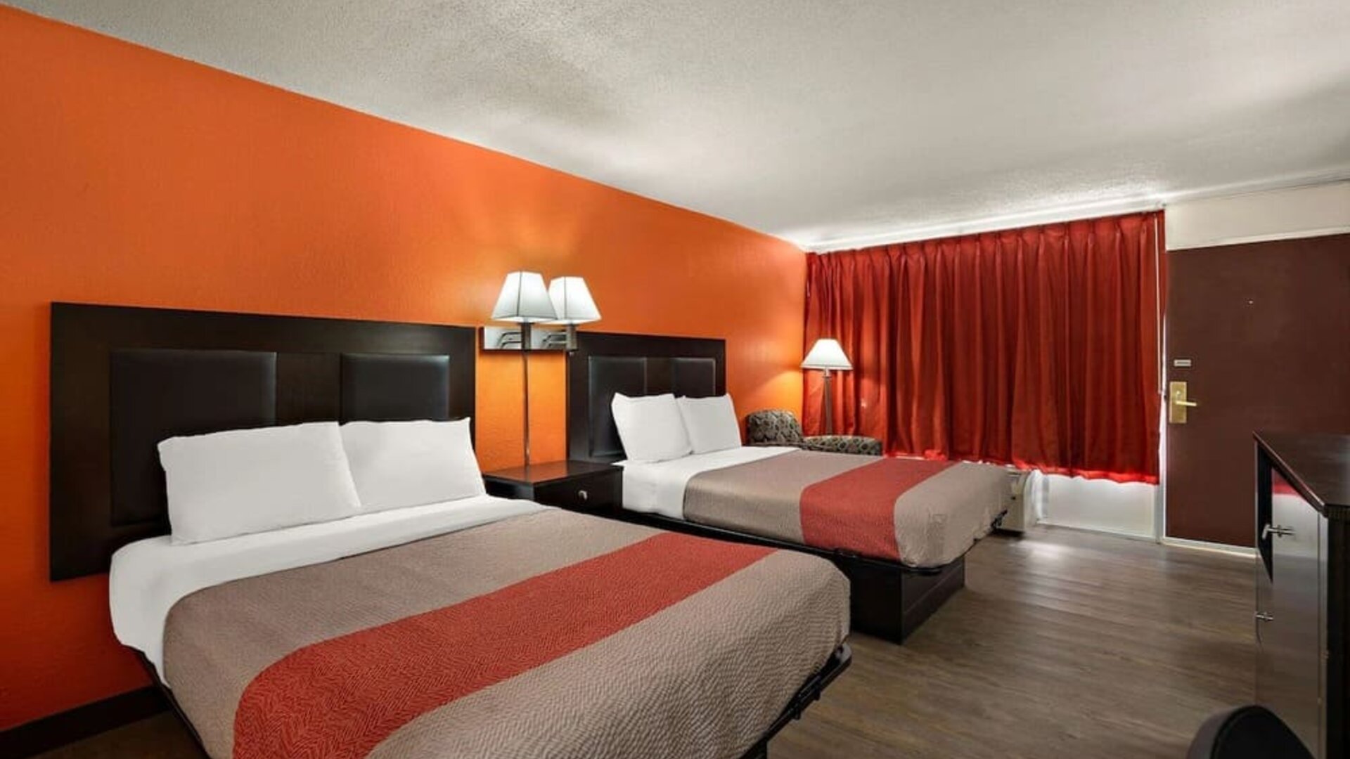 Guest room with two double beds, orange accent wall and exterior entry door at Econo Lodge Yemassee.