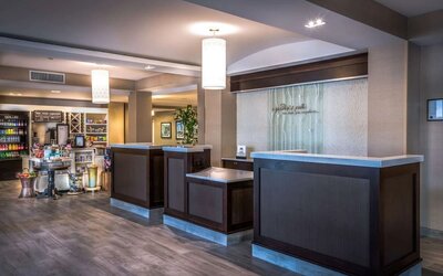Modern hotel reception area with front desk, lobby market, and welcoming check-in space for arriving guests.