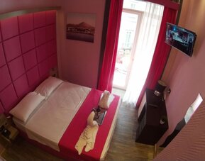 Bright double room with balcony access, flat-screen TV and modern décor at Dolce Vita Rooms & Breakfast.