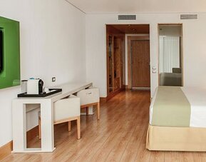 Contemporary guest room with king bed, workspace, flat-screen TV and modern furnishings at NH Collection Mexico City Airport T2.