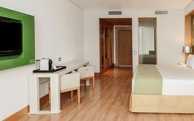 Contemporary guest room with king bed, workspace, flat-screen TV and modern furnishings at NH Collection Mexico City Airport T2.