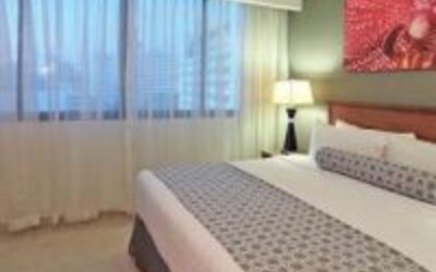 Bright guest room with king bed, large window and contemporary furnishings at Crowne Plaza Panama.