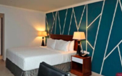 Spacious guest room with king bed, work desk, lounge chair and stylish feature wall at Crowne Plaza Panama.