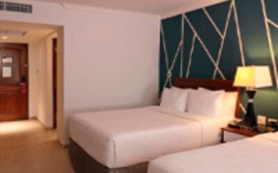 Modern guest room with two double beds, accent feature wall and contemporary décor at Crowne Plaza Panama.