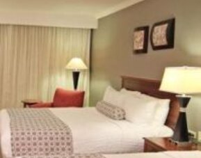 Bright guest room with two double beds, bedside lighting and comfortable seating at Crowne Plaza Panama.