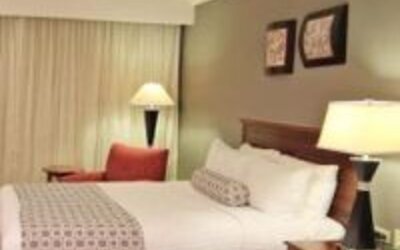 Bright guest room with two double beds, bedside lighting and comfortable seating at Crowne Plaza Panama.