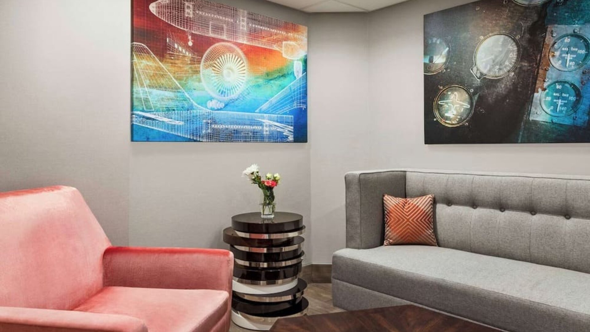 Comfortable hotel lounge with modern seating, contemporary artwork and a welcoming space to relax at Hampton Inn Chicago O'Hare.