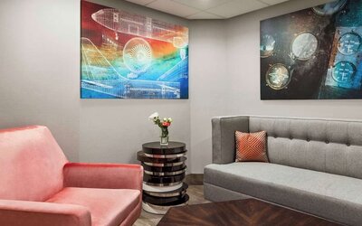 Comfortable hotel lounge with modern seating, contemporary artwork and a welcoming space to relax at Hampton Inn Chicago O'Hare.