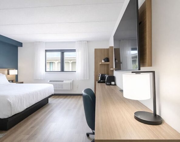 In-room workspace featuring a spacious desk, flat-screen TV, coffee station and comfortable king bed at Hyatt Select Philadelphia Airport.