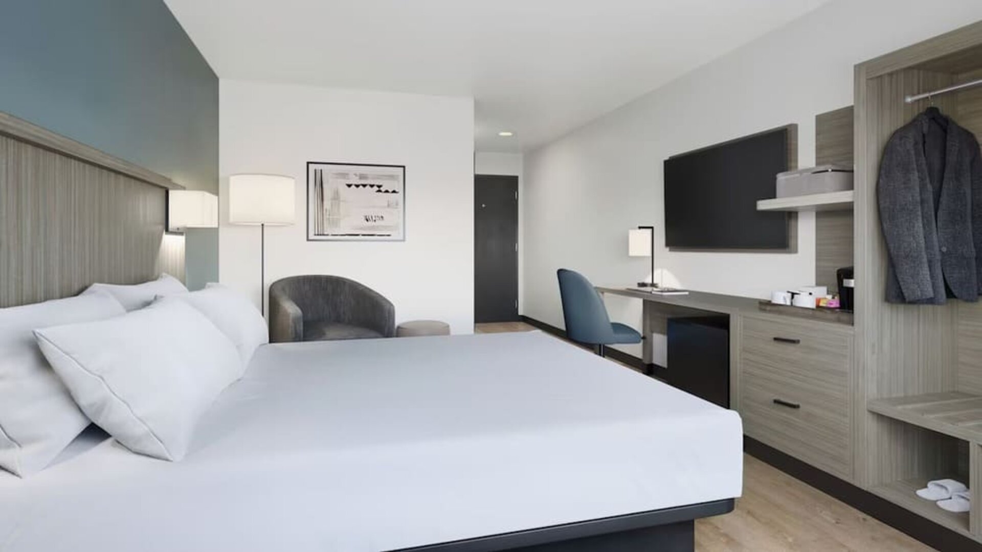 Contemporary guest room with a king bed, workspace, flat-screen TV, coffee station and open wardrobe at Hyatt Select Philadelphia Airport.