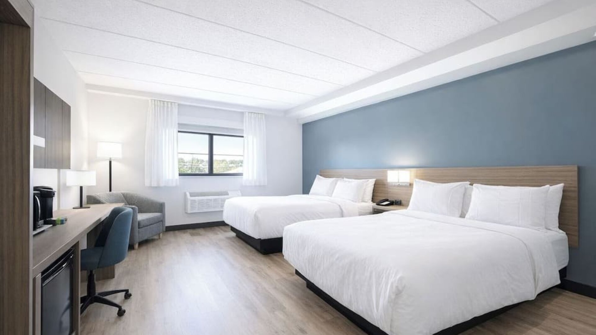 Bright guest room with two queen beds, work desk, mini fridge and coffee maker at Hyatt Select Philadelphia Airport.