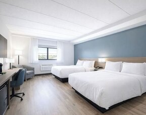 Bright guest room with two queen beds, work desk, mini fridge and coffee maker at Hyatt Select Philadelphia Airport.