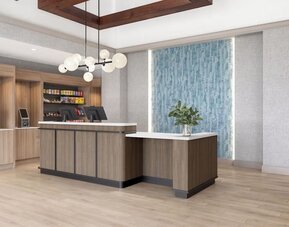 Hotel reception area featuring a modern front desk, snack market and welcoming lobby at Hyatt Select Philadelphia Airport.