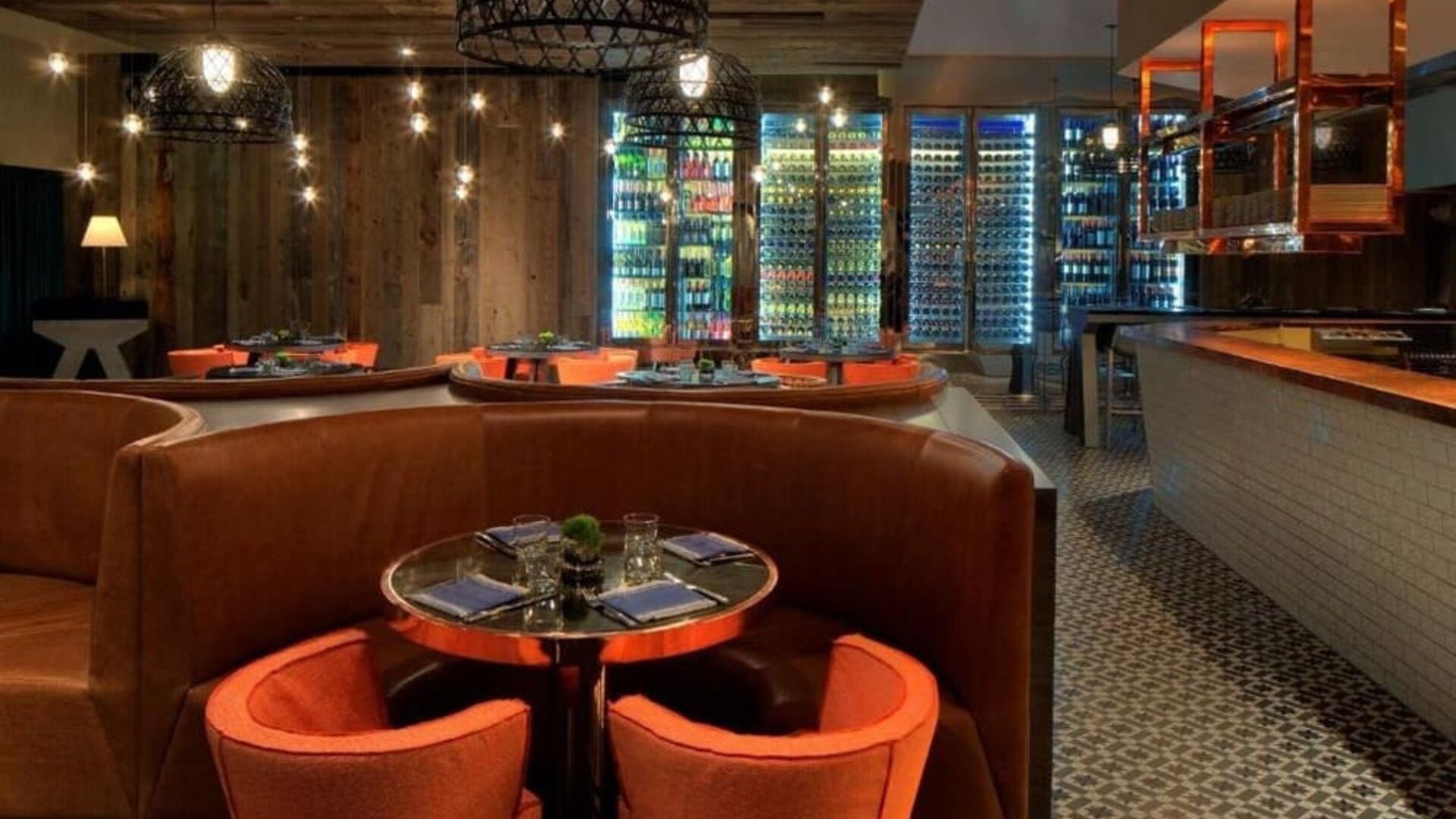 Stylish hotel restaurant with warm wood accents, cozy booth seating and illuminated wine displays at Royal Sonesta Minneapolis.