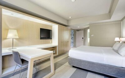 Bright guest room featuring a king bed, large work desk, flat-screen TV and modern furnishings at Royal Sonesta Minneapolis.