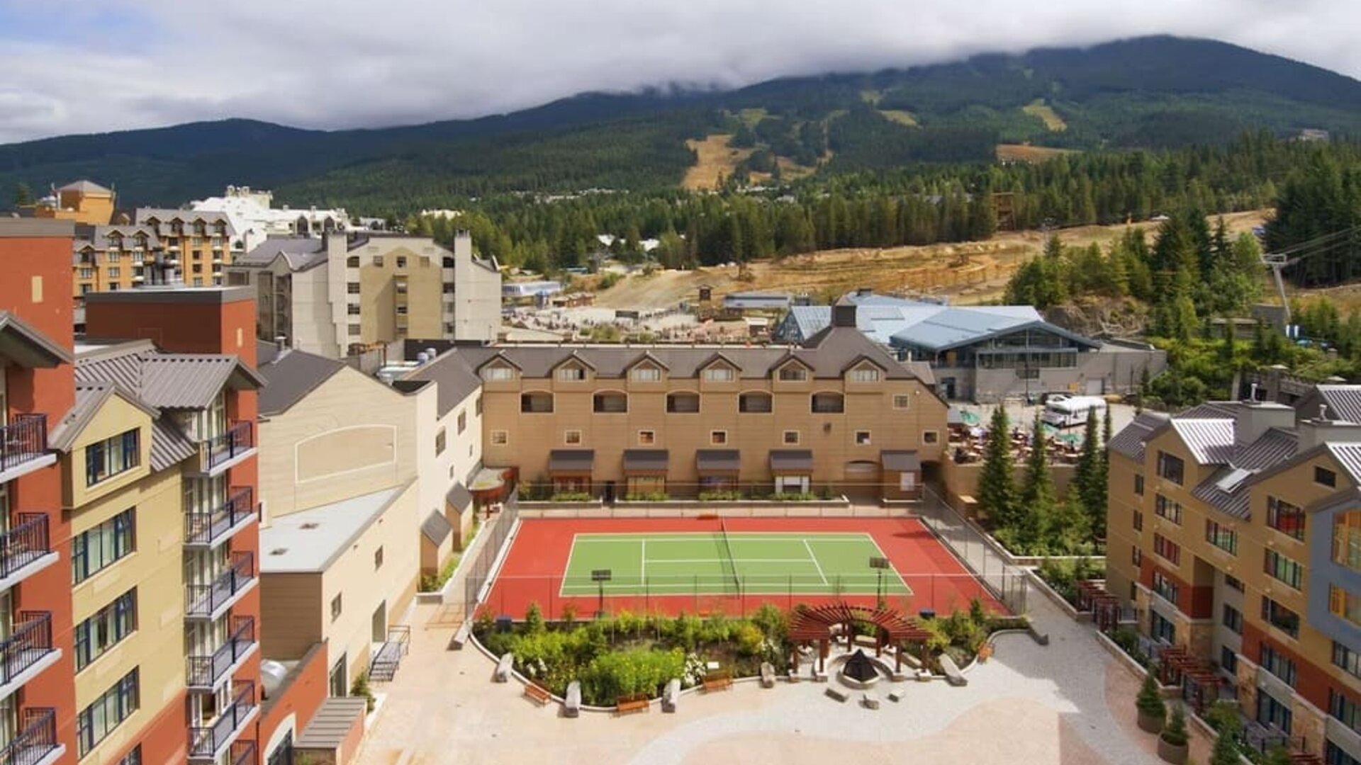 Hotel outdoor with tennis courtyard and lounge area at Hilton Whistler Resort & Spa.