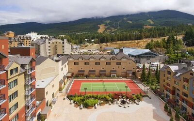 Hotel outdoor with tennis courtyard and lounge area at Hilton Whistler Resort & Spa.