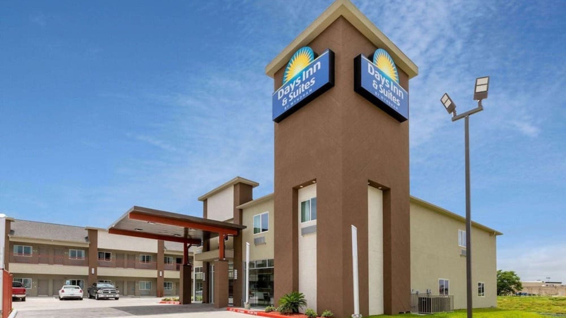 Exterior view of Days Inn & Suites By Wyndham Downtown/University Of Houston featuring the hotel building, entrance and branded signage.