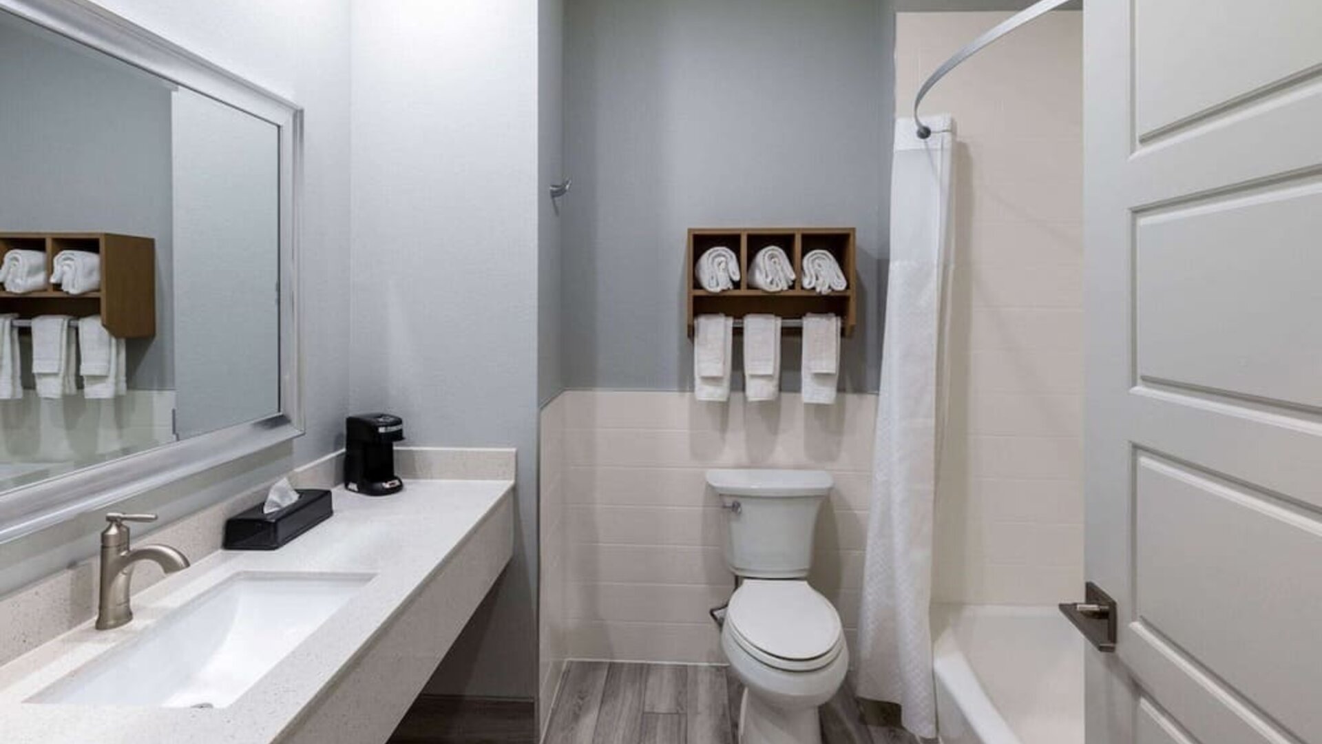 Guest bathroom at Days Inn & Suites By Wyndham Downtown/University Of Houston featuring a vanity, toilet and shower-tub combination.