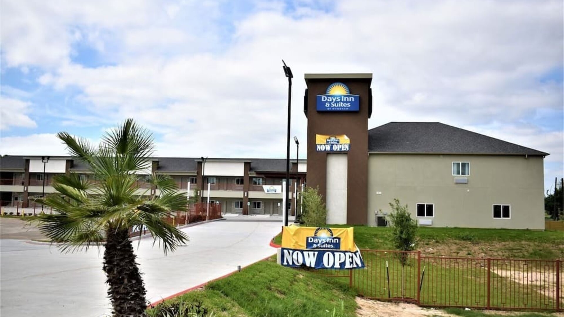 Exterior view of Days Inn & Suites By Wyndham Downtown/University Of Houston featuring the hotel building and prominent roadside signage.