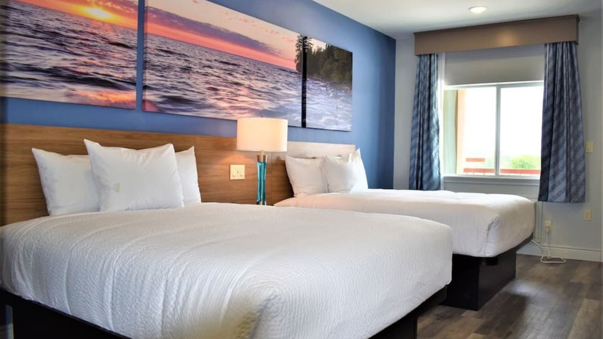 Guest room at Days Inn & Suites By Wyndham Downtown/University Of Houston featuring two beds, a large window and natural light.