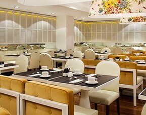 Dining area at Hotel Pulitzer Buenos Aires featuring neatly arranged tables, upholstered seating and contemporary overhead lighting.