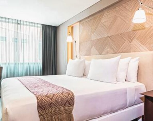 Guest room at NH Collection Mexico City Centro Histórico featuring a large bed, work desk, bedside lighting and contemporary furnishings.