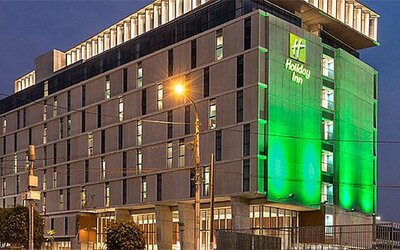 Exterior view of Holiday Inn Lima Airport featuring the multi-story hotel building illuminated at night.