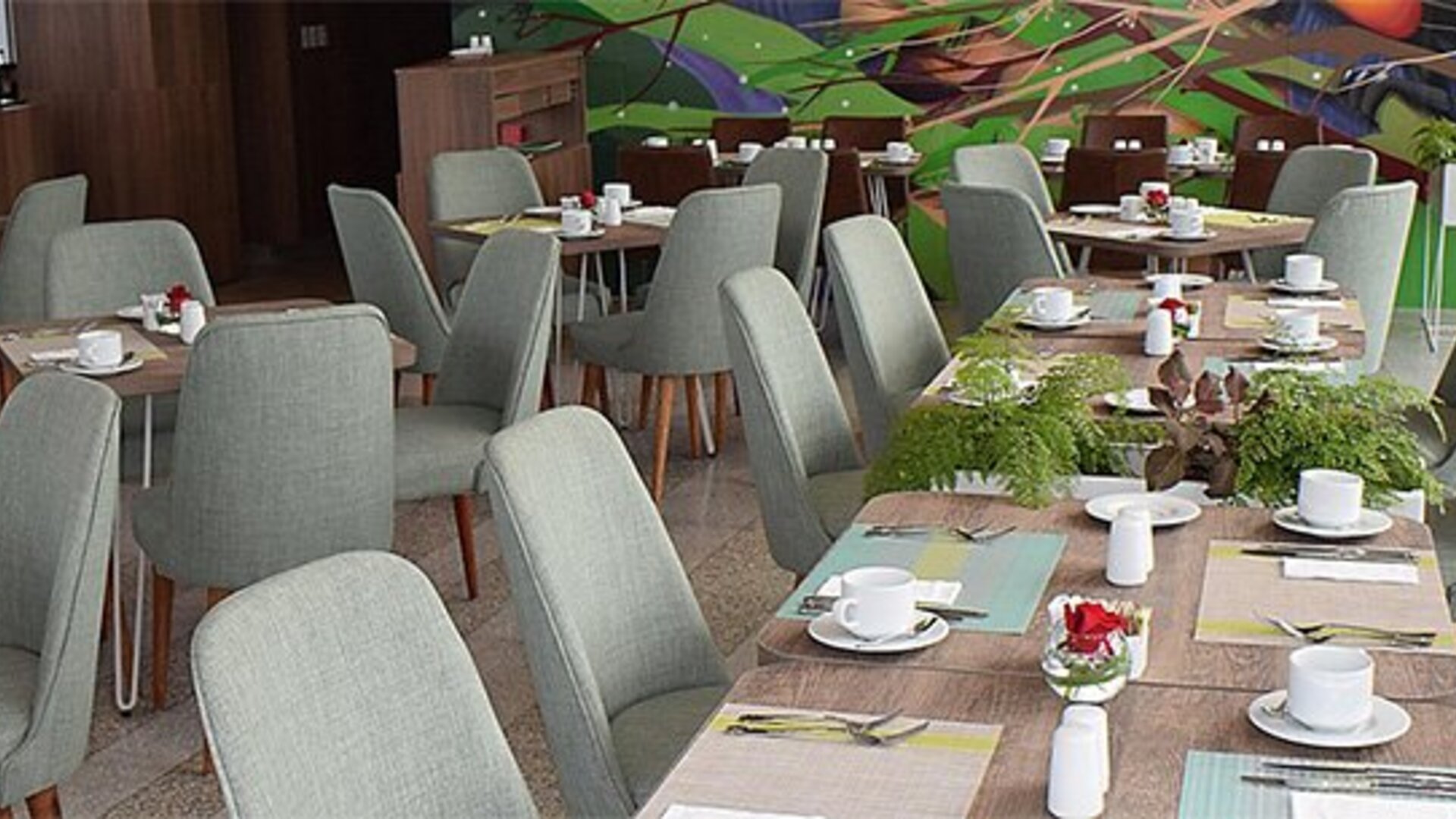 Restaurant at Holiday Inn Lima Airport featuring neatly arranged dining tables, upholstered chairs and colorful wall artwork.