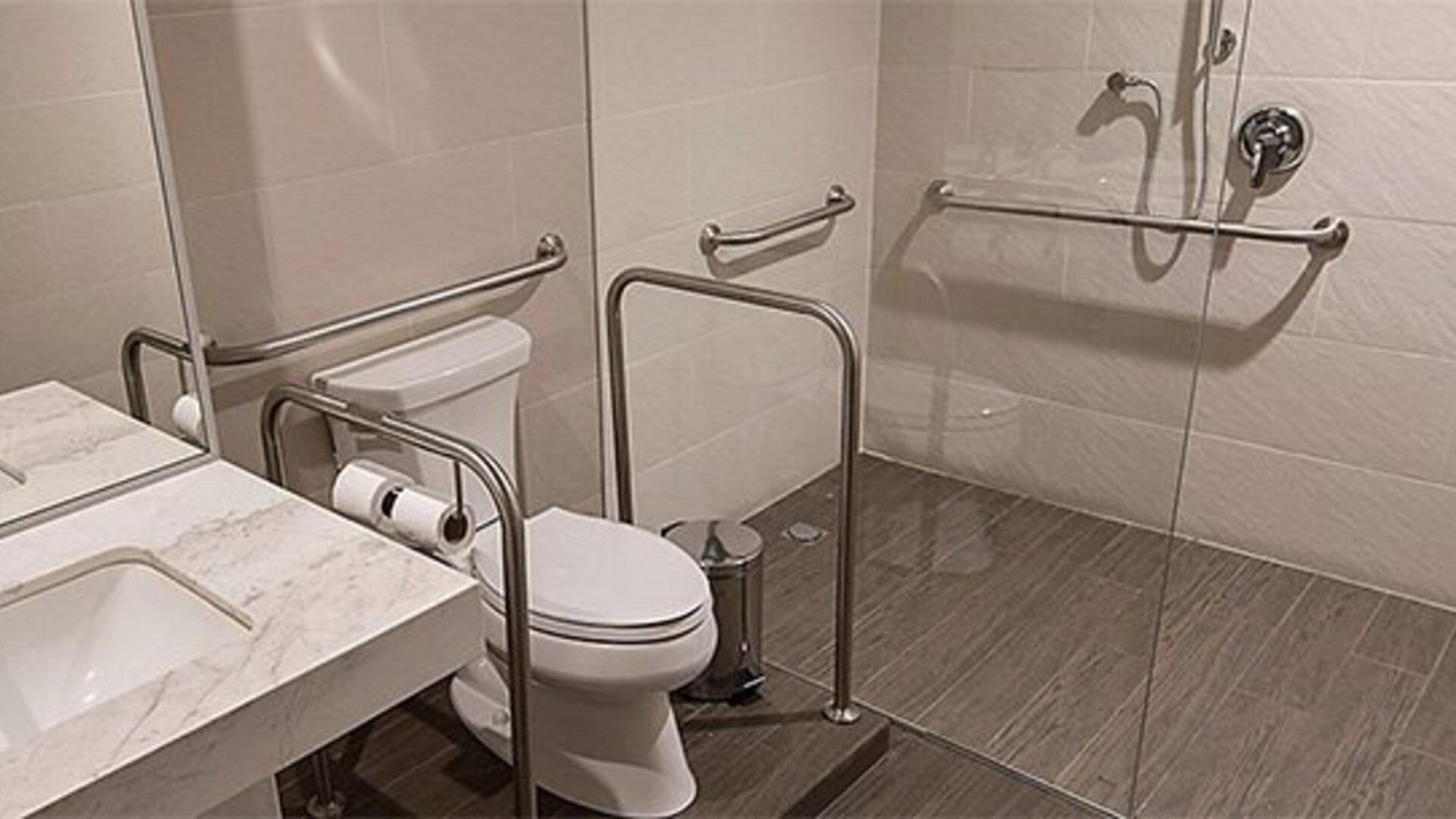 Accessible bathroom at Holiday Inn Lima Airport featuring a walk-in shower, grab bars, toilet and vanity sink.