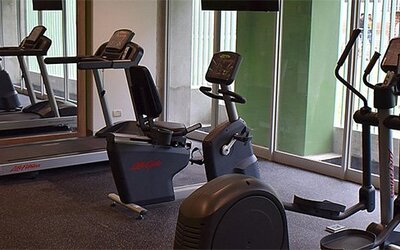 Fitness center at Holiday Inn Lima Airport featuring treadmills, stationary bikes, elliptical machines and mirrored walls.