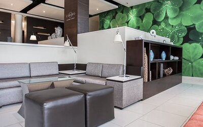 Lobby seating area at Courtyard Panama Metromall featuring sofas, ottomans, individual reading lamps and a green feature wall.