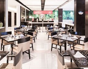 Dining area at Courtyard Panama Metromall featuring neatly set tables, modern chairs and bright contemporary décor.