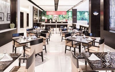 Dining area at Courtyard Panama Metromall featuring neatly set tables, modern chairs and bright contemporary décor.