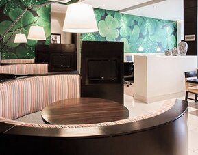 Lobby workspace at Courtyard Panama Metromall featuring curved booth seating, tables and contemporary pendant lighting.