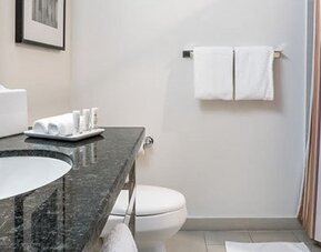 Guest bathroom at Courtyard Panama Metromall featuring a granite vanity, bathtub with shower and complimentary toiletries.