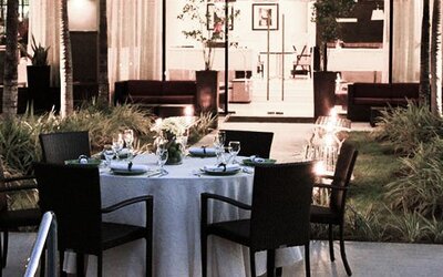 Outdoor dining area at Courtyard Panama Metromall featuring a set dining table surrounded by landscaped gardens.