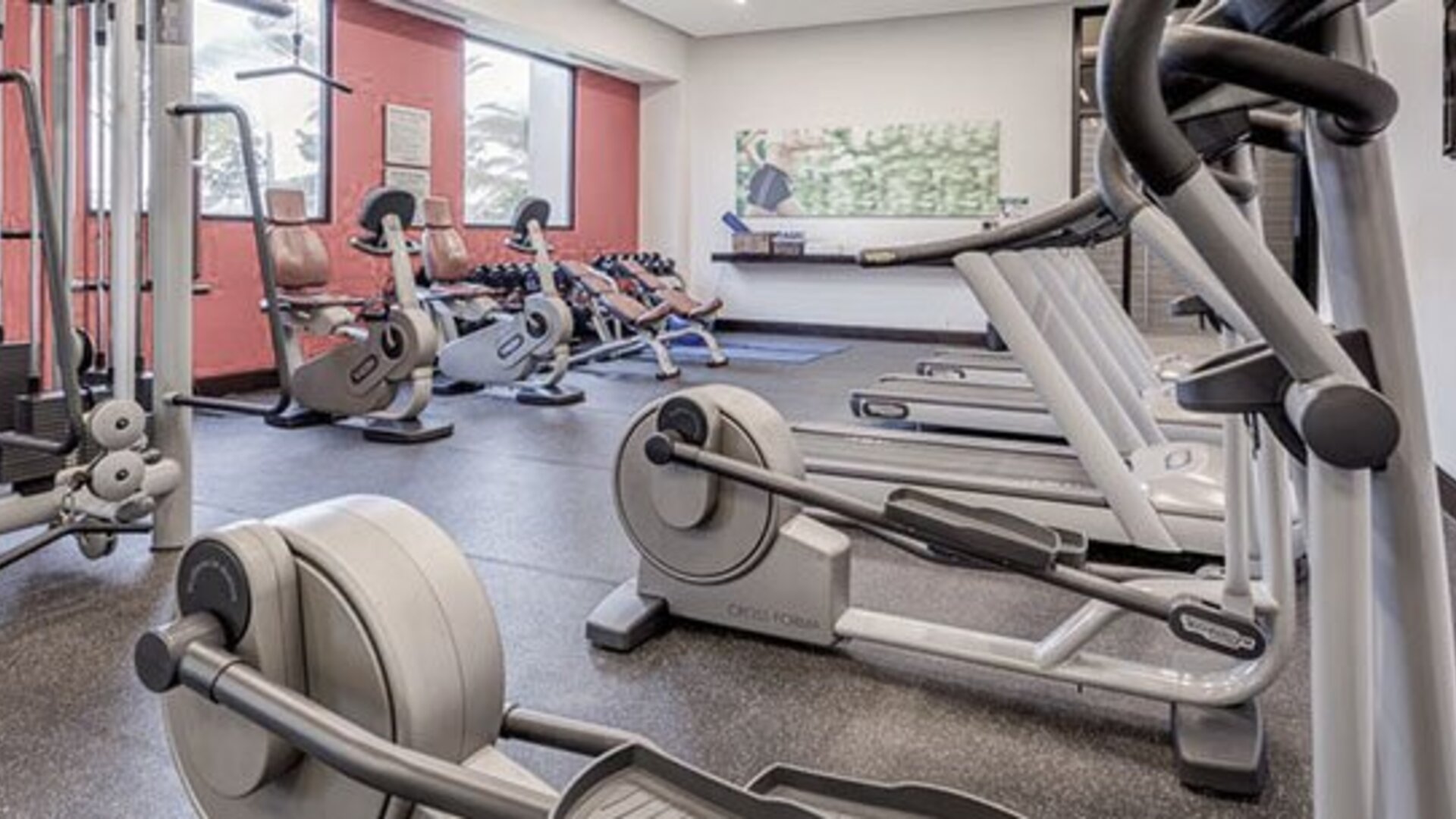 Fitness center at Courtyard Panama Metromall featuring treadmills, stationary bikes, weight equipment and large windows