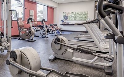 Fitness center at Courtyard Panama Metromall featuring treadmills, stationary bikes, weight equipment and large windows